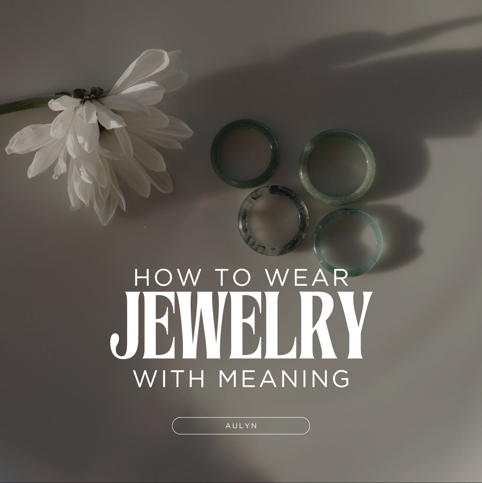Jade rings in a plate next to a flower