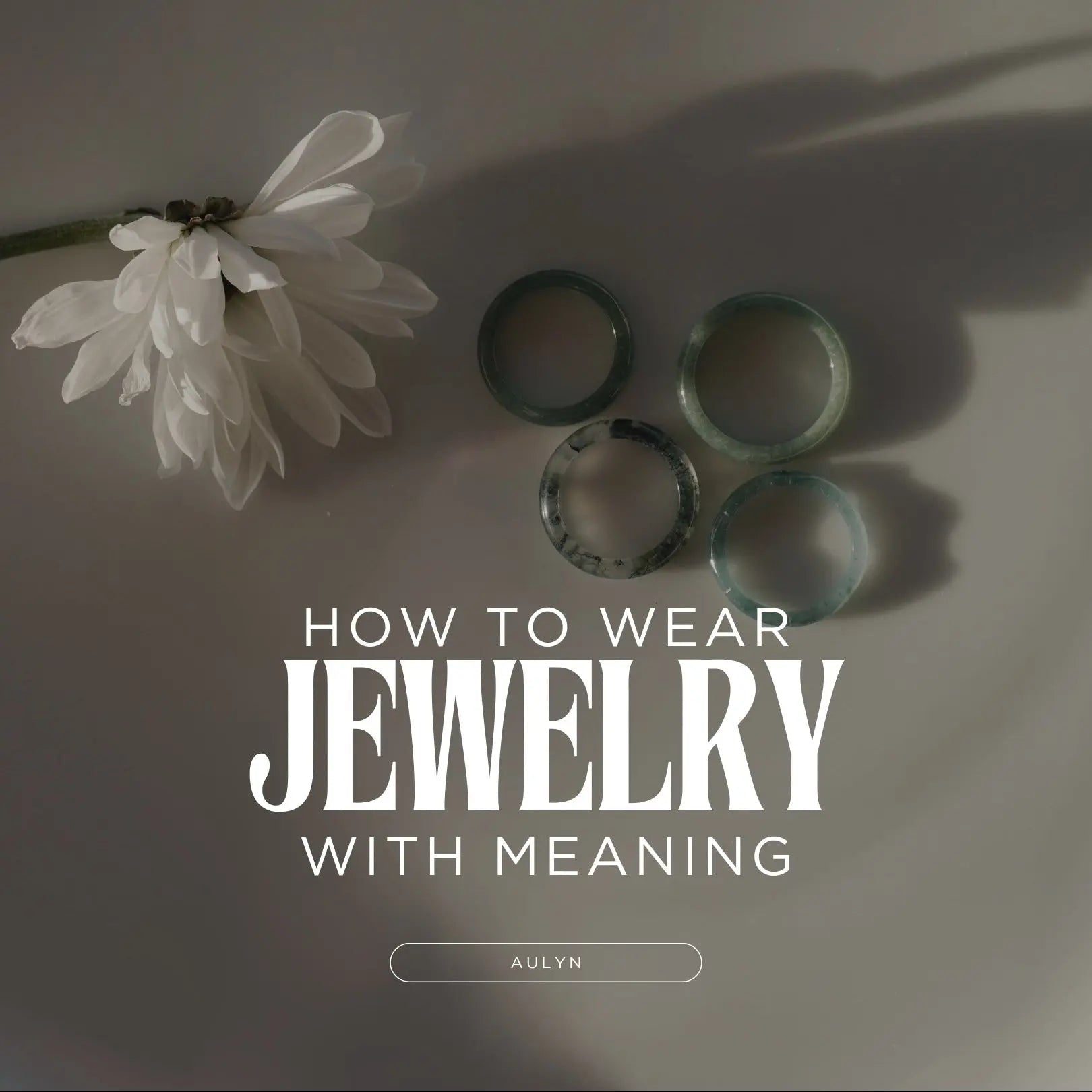 Jade rings in a plate next to a flower
