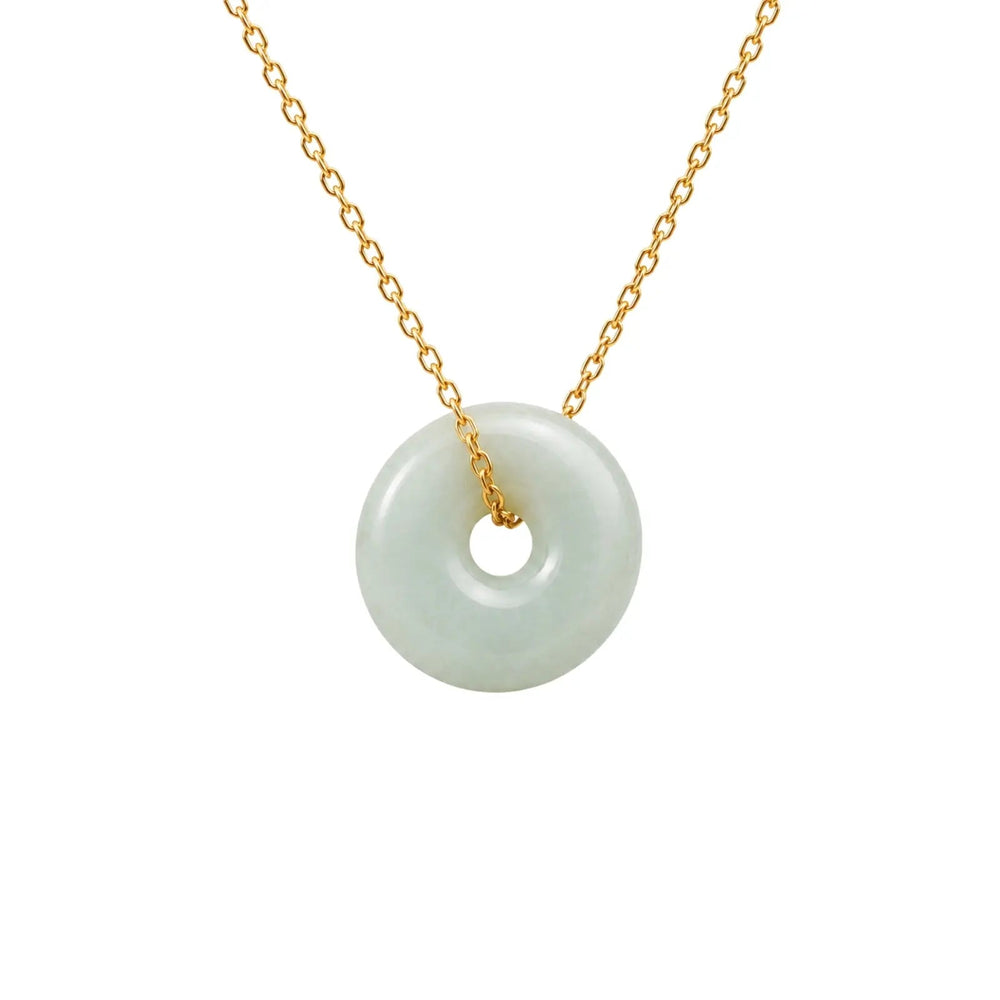 Necklace with a jade pendant on a gold chain against a white background
