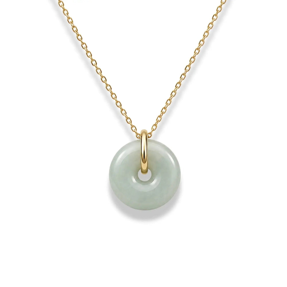 Necklace with a gold chain and green jade pendant on a white background