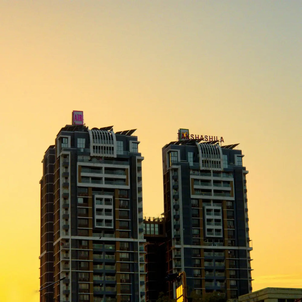 a couple of tall buildings sitting next to each other - Photo by Karan Suthar on Unsplash