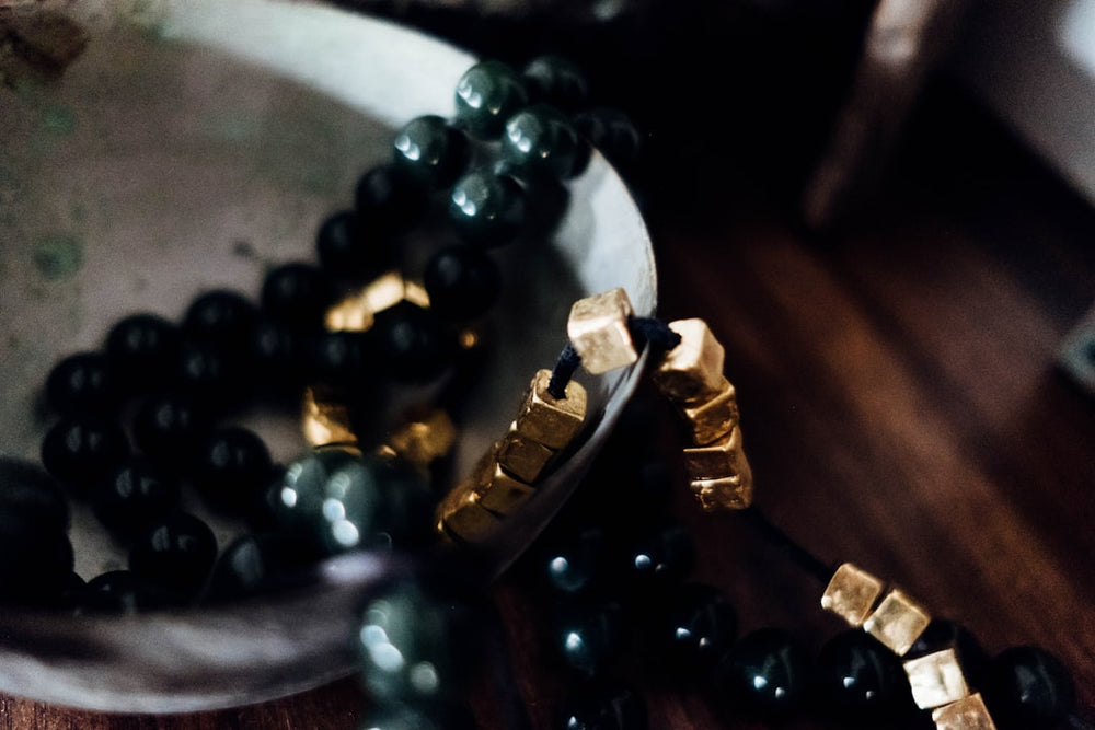 beaded black necklace on white surface - Photo by The Tsudons on Unsplash