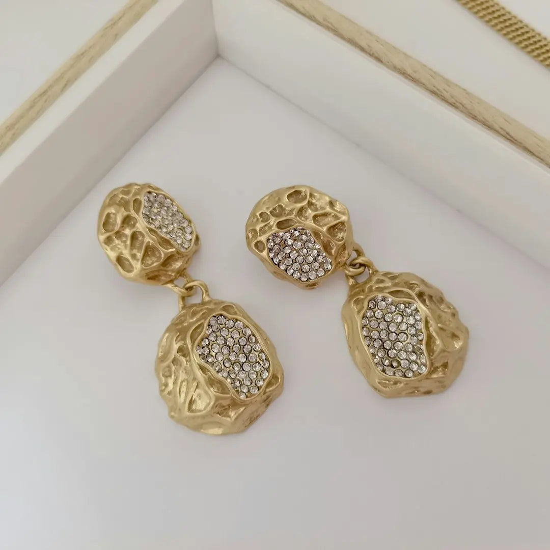 a pair of gold and diamond earrings - Photo by Stephan Koning on Unsplash