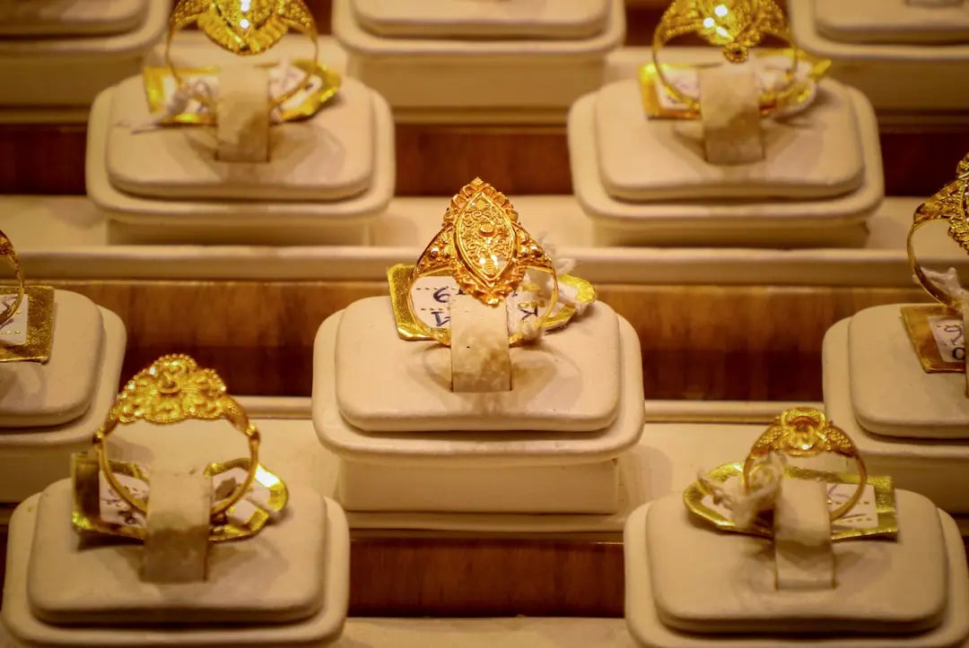 Rows of ornate gold rings displayed on stands. - Photo by Zayed Ahmed Zadu on Unsplash