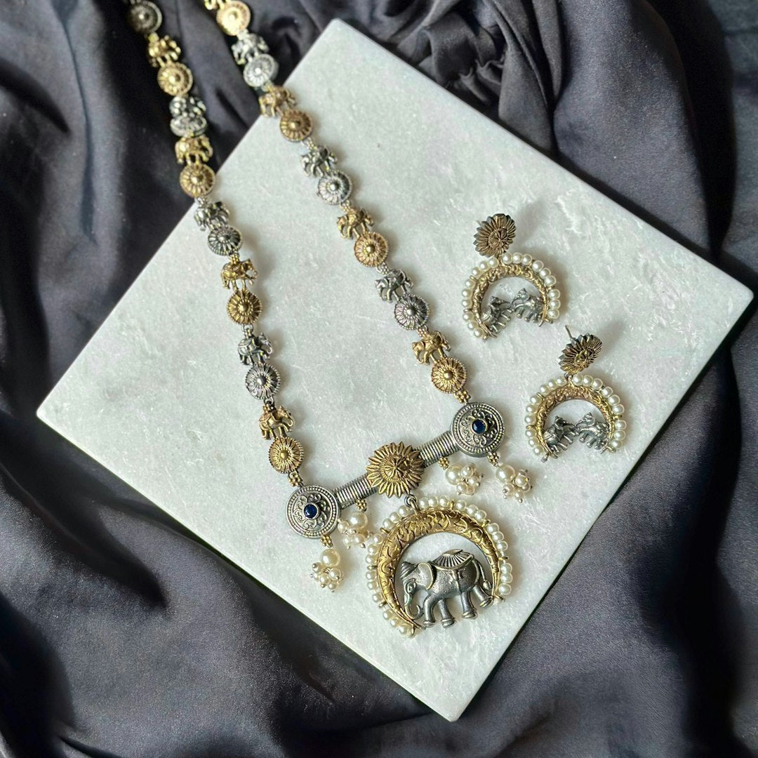 A necklace and earring set sitting on a cloth - Photo by cherriscope lifestyle on Unsplash