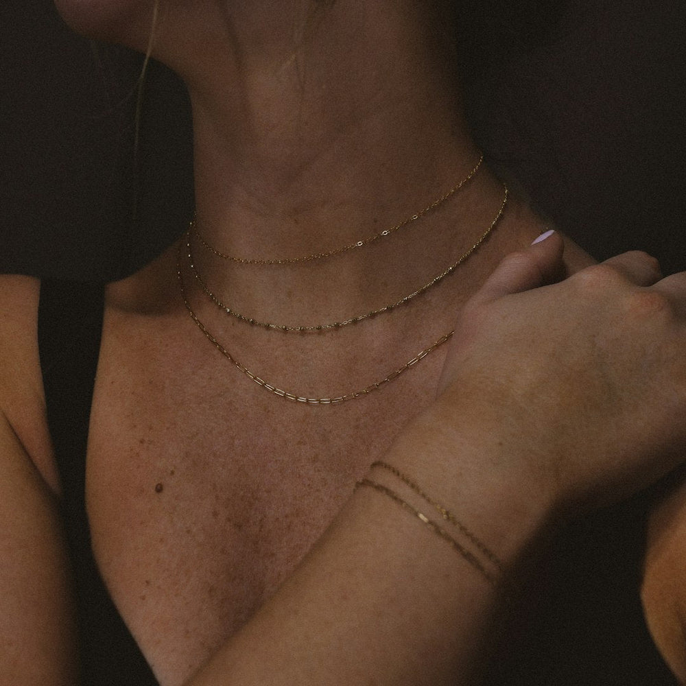 a close up of a person wearing a necklace - Photo by katie ruocco on Unsplash