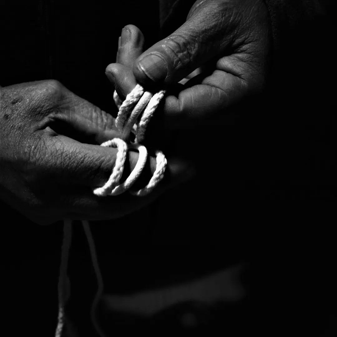grayscale photo of person holding white rope - Photo by Eirini Papadatou on Unsplash