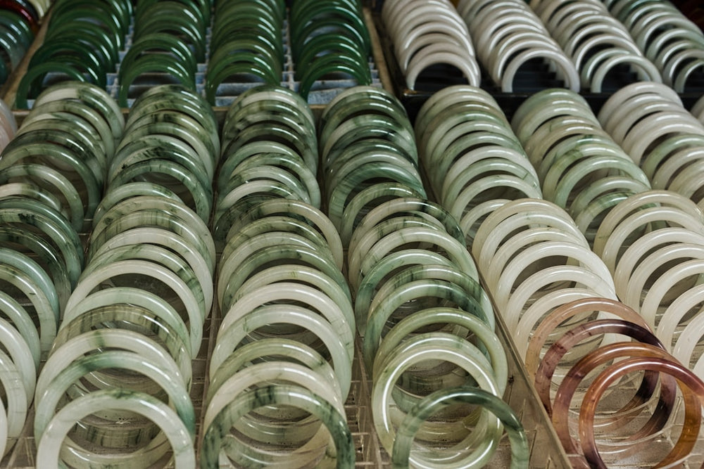 Rows of jade bracelets in various green and white shades - Photo by Eric Prouzet on Unsplash