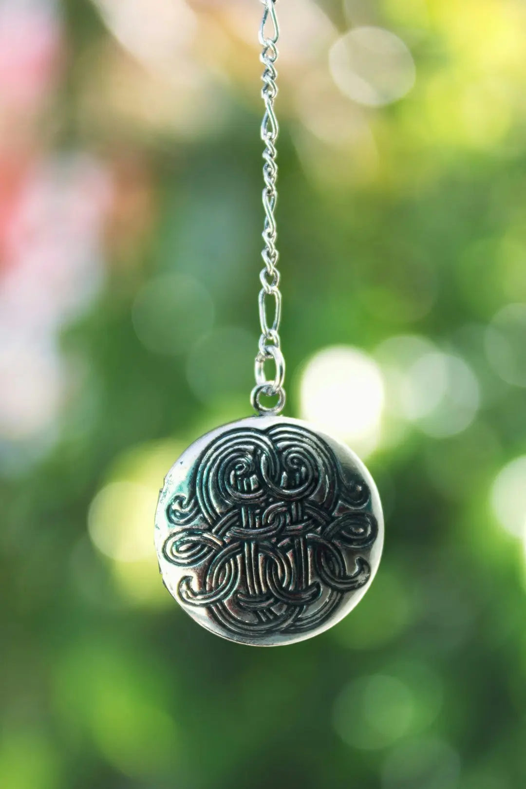 silver round pendant necklace in tilt shift lens - Photo by McCarthy Beckan on Unsplash