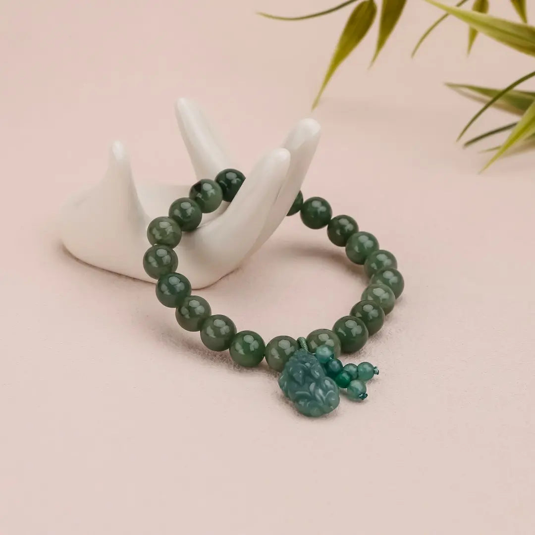 Green beaded bracelet resting on a white hand. - Photo by Keekon on Unsplash