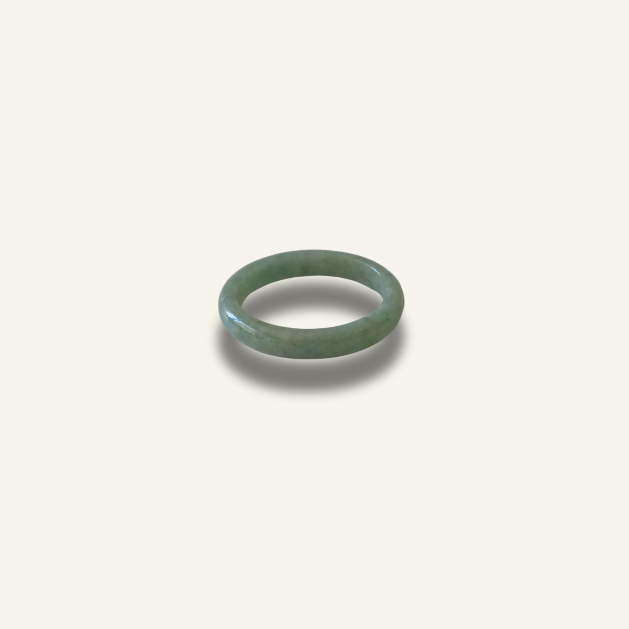 Minimalist solid jadeite ring with a smooth finish, hand-carved to highlight the natural beauty and symbolic meaning of purity, balance, and heritage on a white background.
