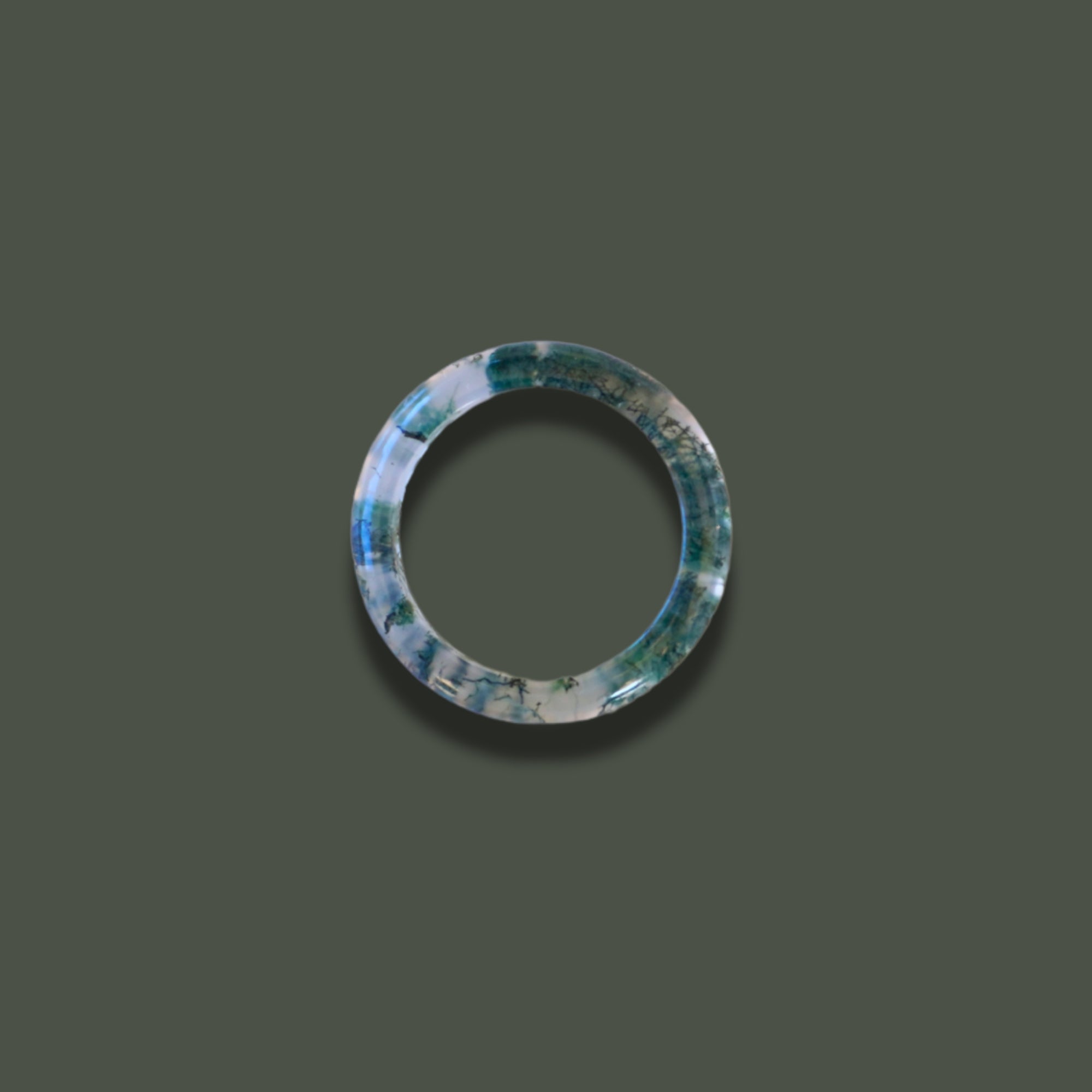Top view of Hand-carved Somae Moss Agate Ring with natural green inclusions, minimalist round band displayed on neutral background
