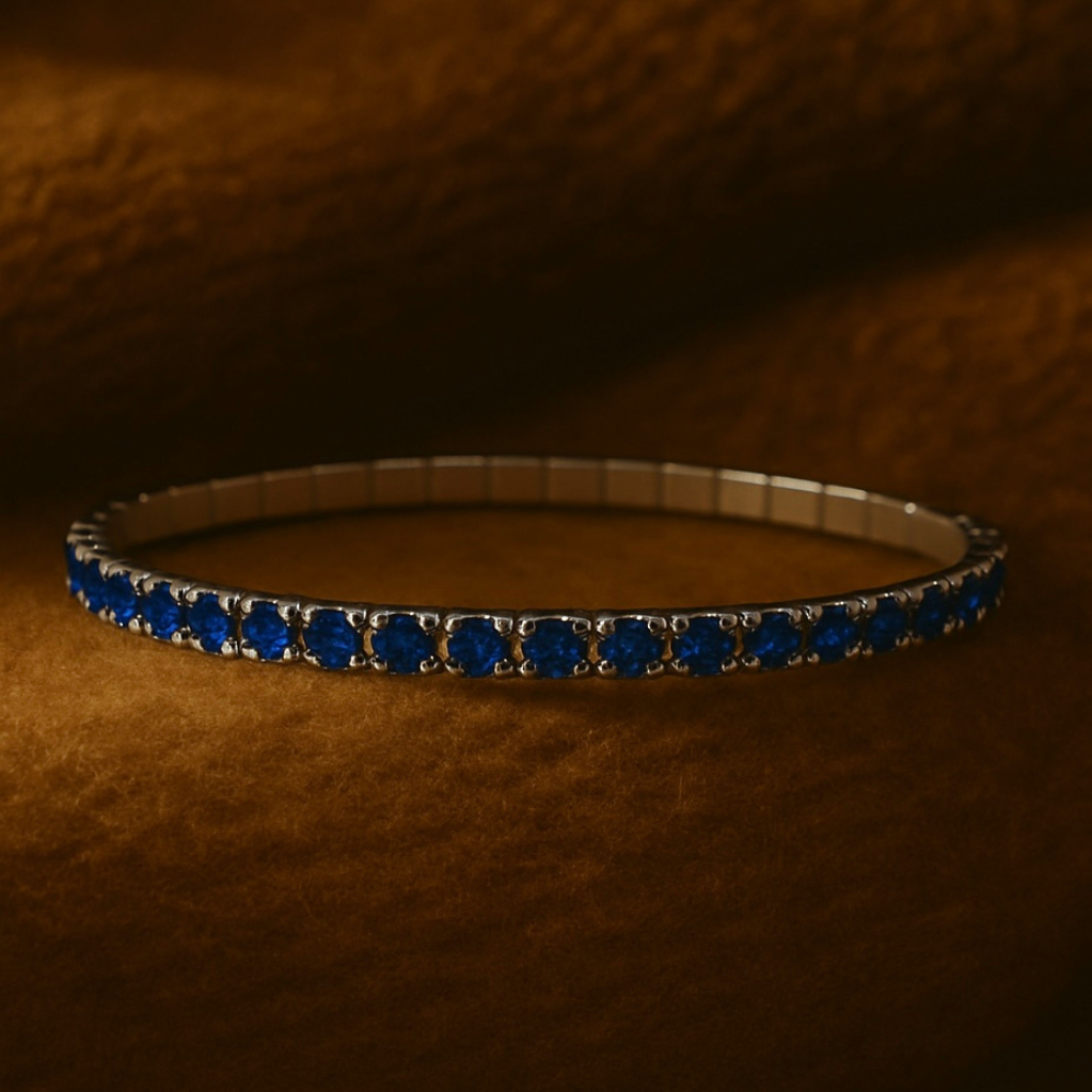 Silver bracelet with blue stones on a brown textured background