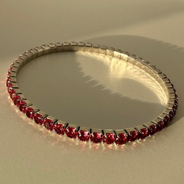 Bracelet with red gemstones on a beige background