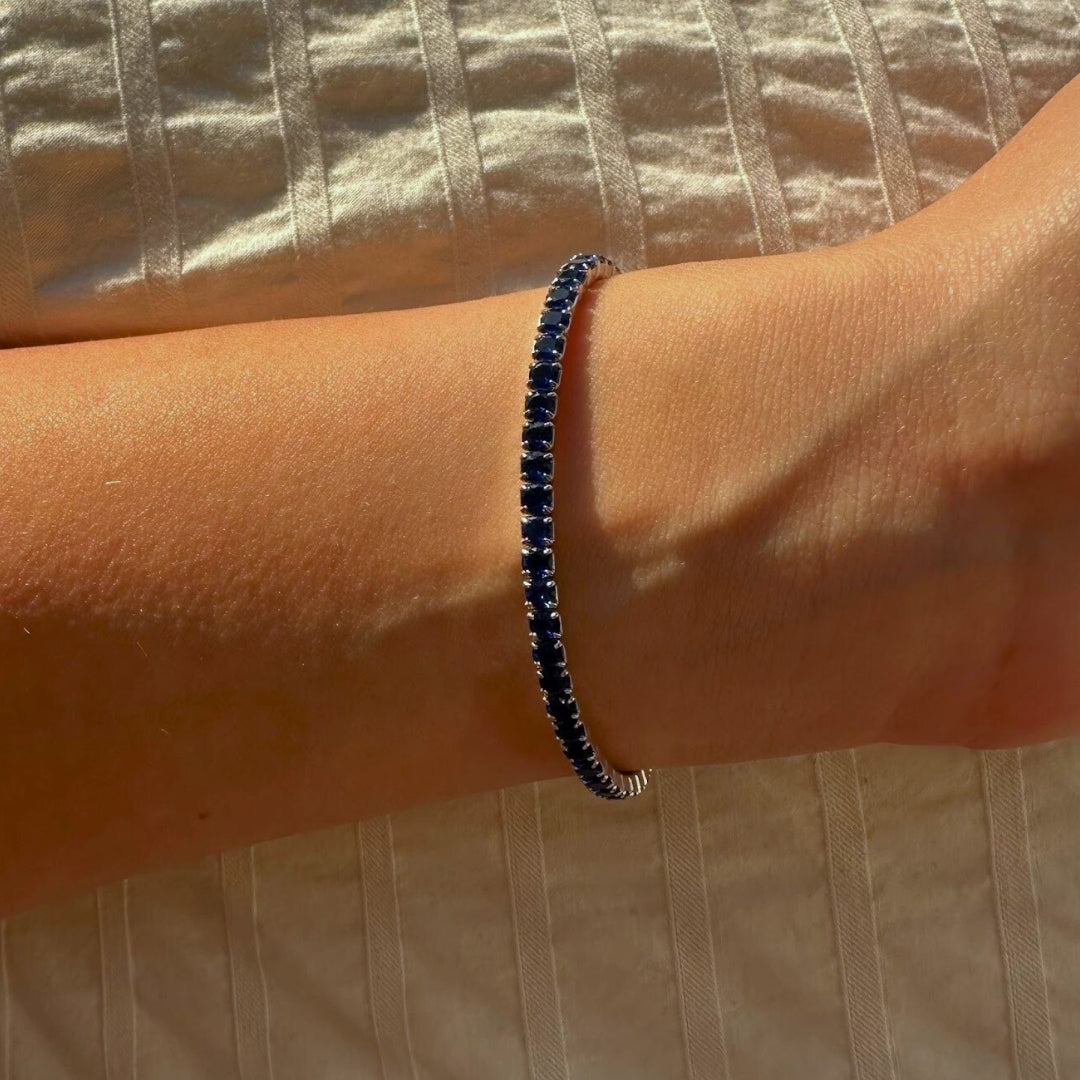 Black beaded bracelet on a wrist with a neutral background