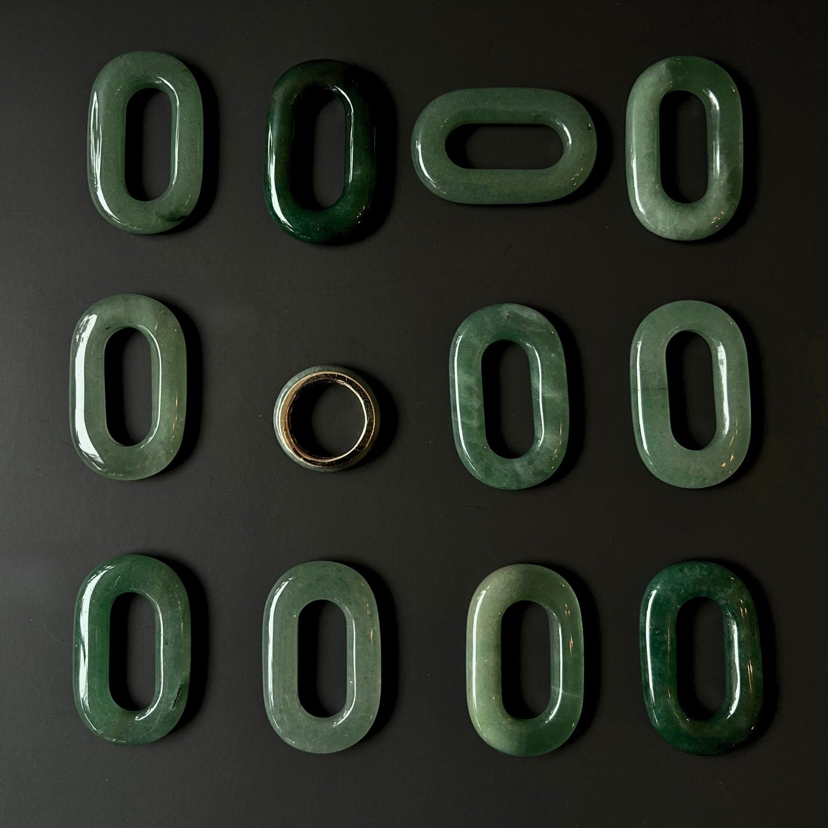 Top-down view of the Jaura Ring showing smooth gold band and green jadeite stone.