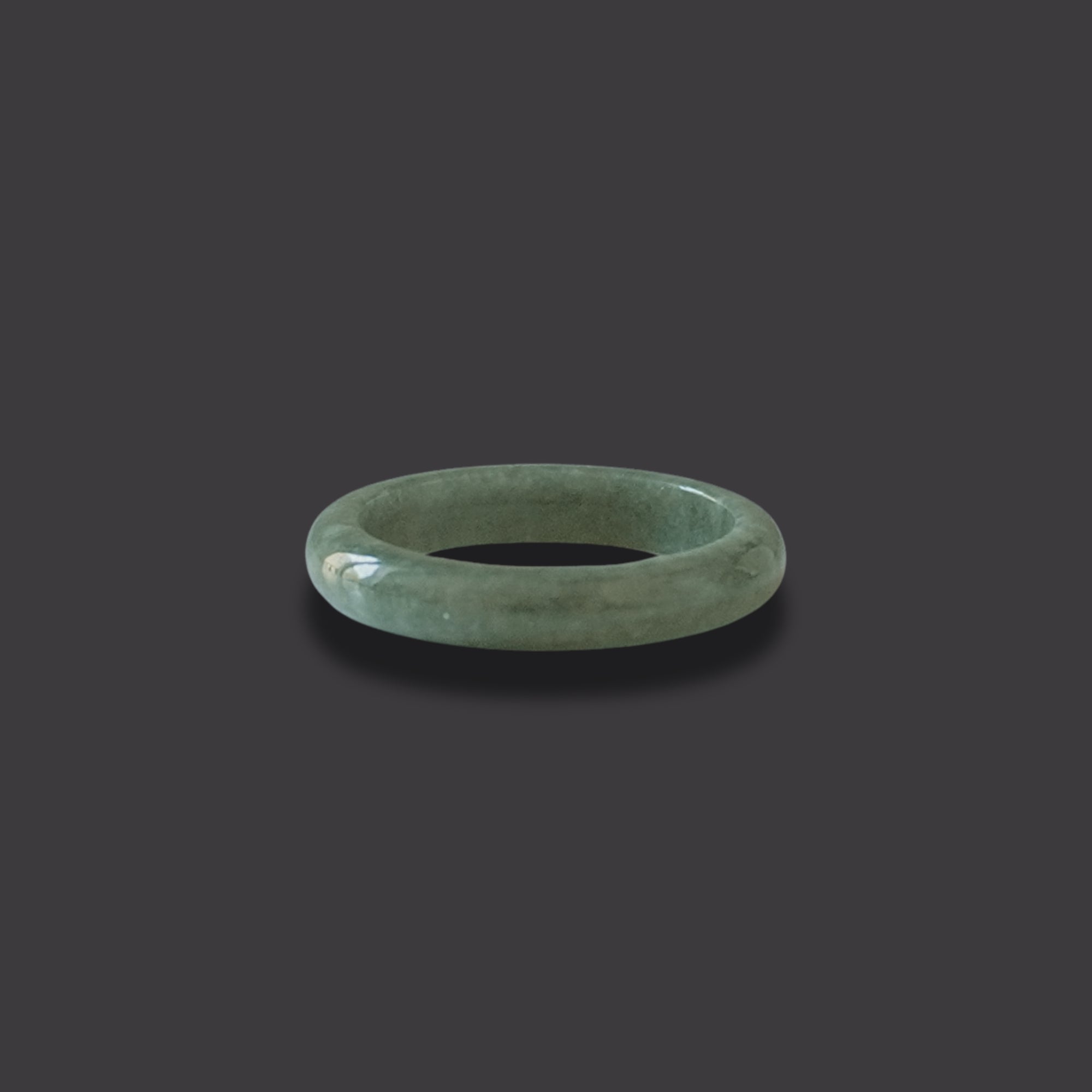 Side View of a Minimalist solid jadeite ring with a smooth finish, hand-carved to highlight the natural beauty and symbolic meaning of purity, balance, and heritage.