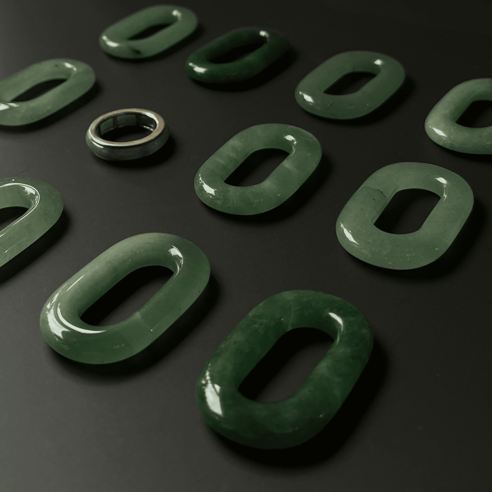 Top-down view of the Jaura Ring showing smooth gold band and green jadeite stone.
