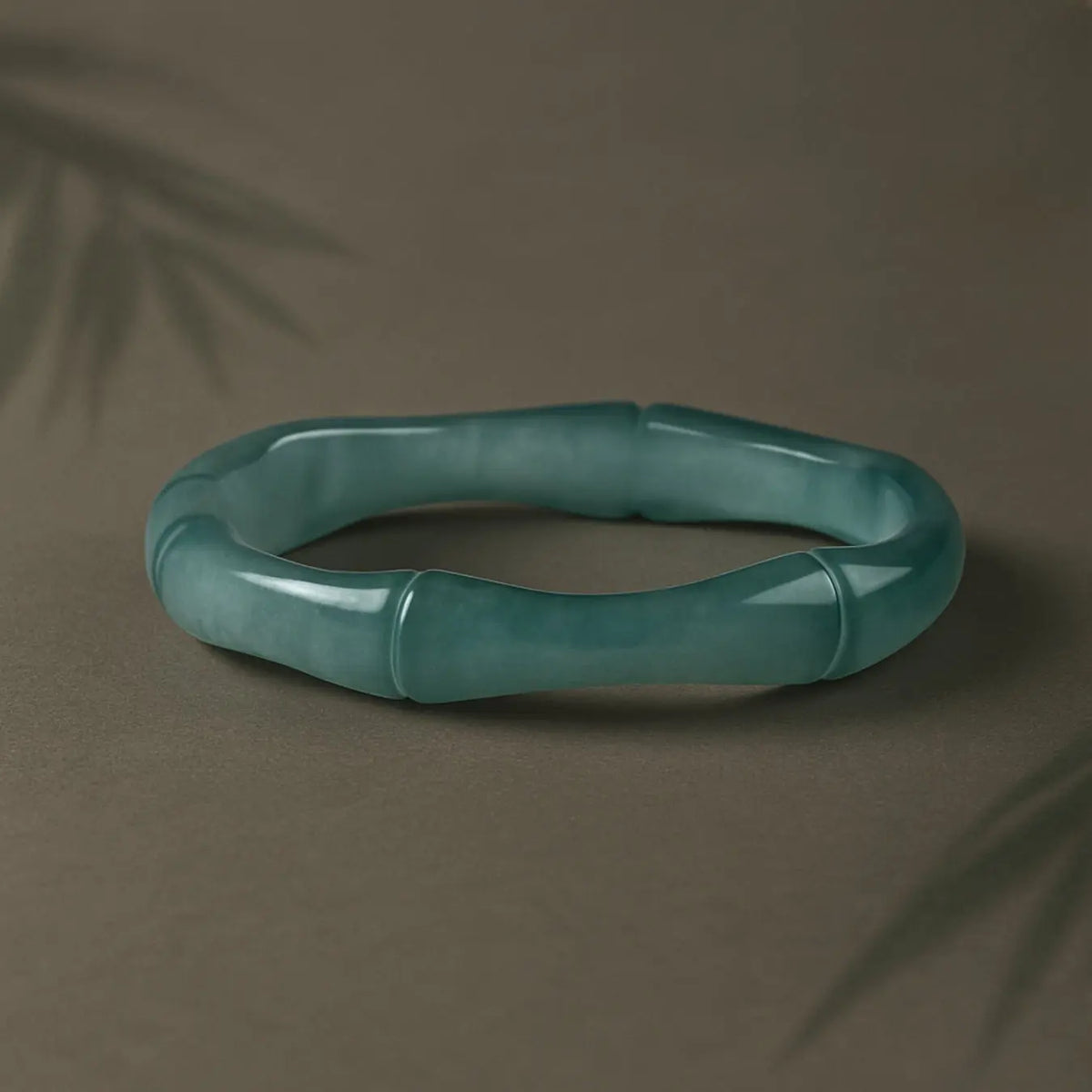 Light green Luwen Jade ring on white ceramic cat jewelry holder, minimalist product display on green background.