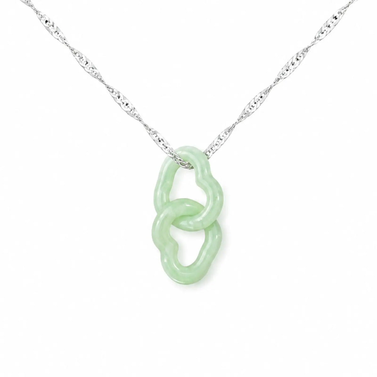 Necklace with a green pendant in a box on a gray fabric background