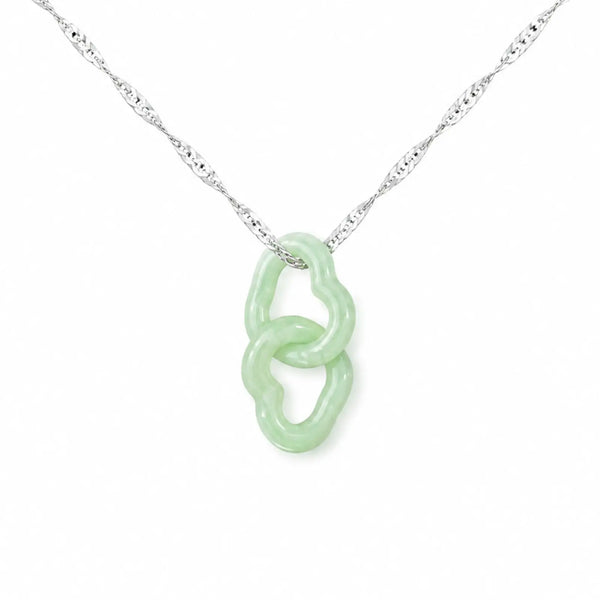 Necklace with a green pendant in a box on a gray fabric background