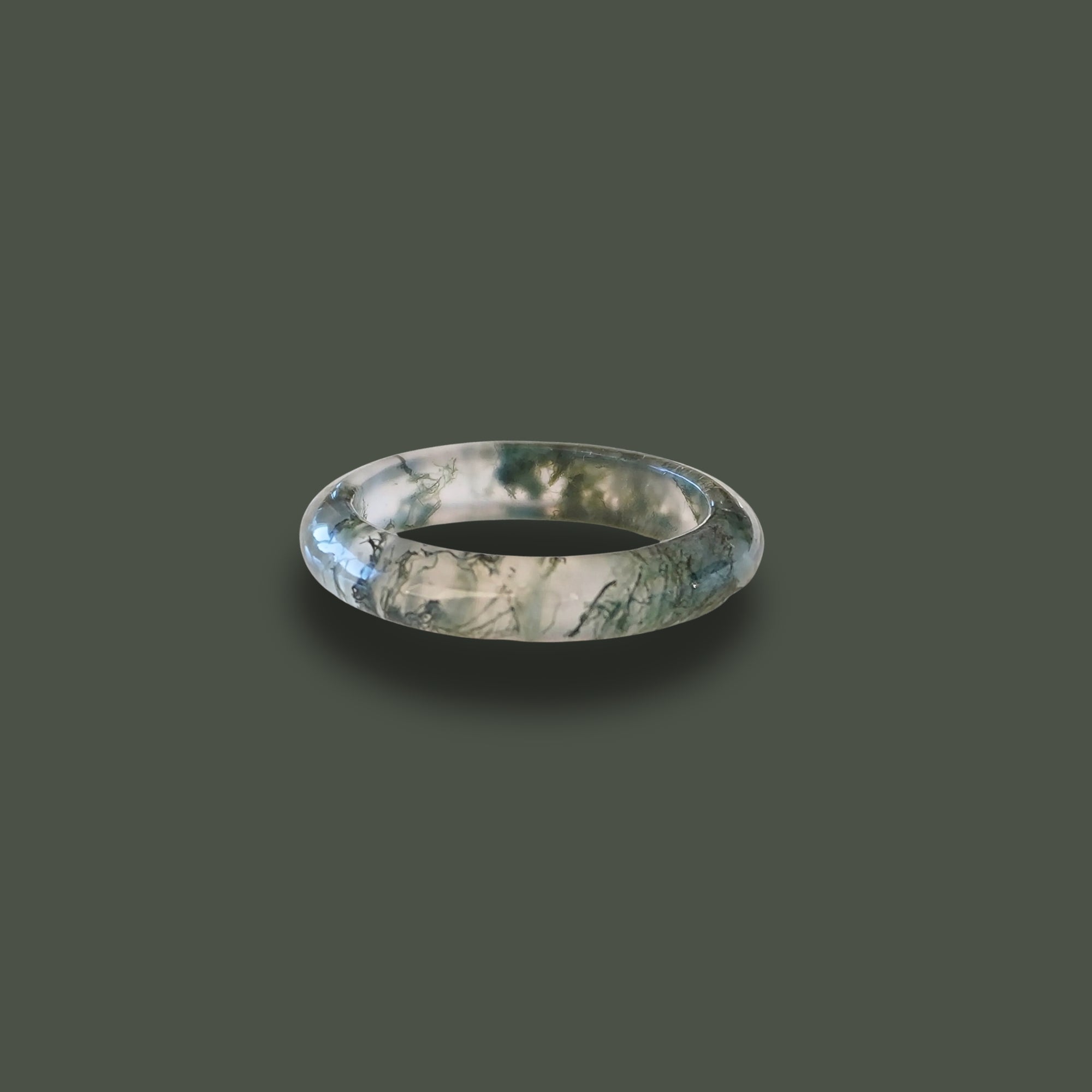 Hand-carved Somae Moss Agate Ring with natural green inclusions, minimalist round band displayed on neutral background.