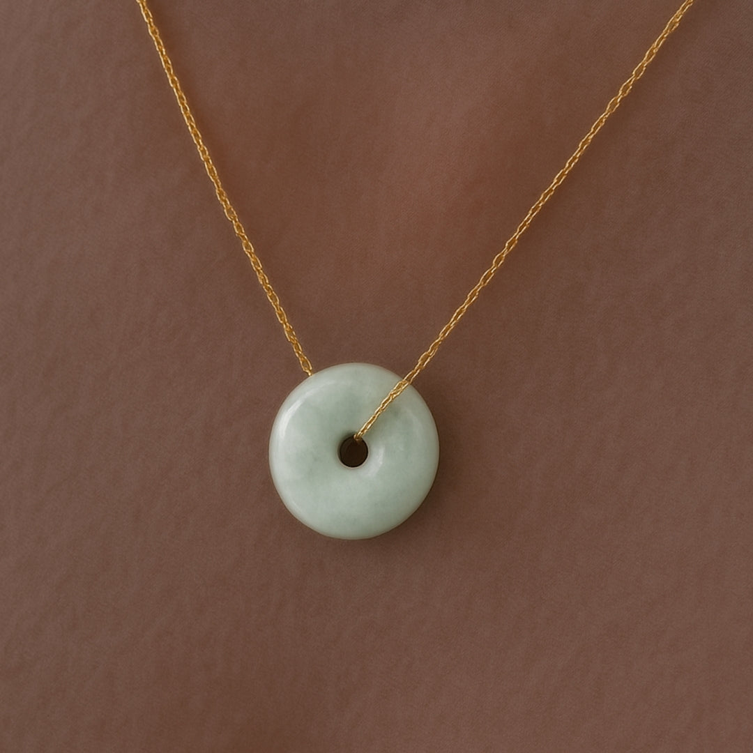 Necklace with a green donut-shaped pendant on a brown background
