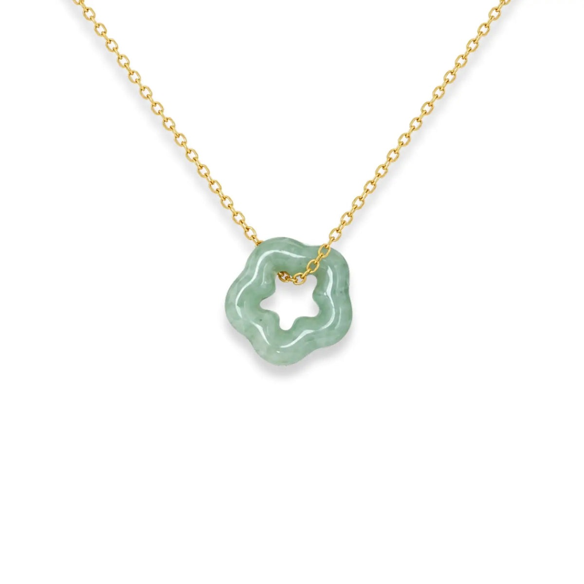 Necklace with a green pendant on a black card against a white fabric background