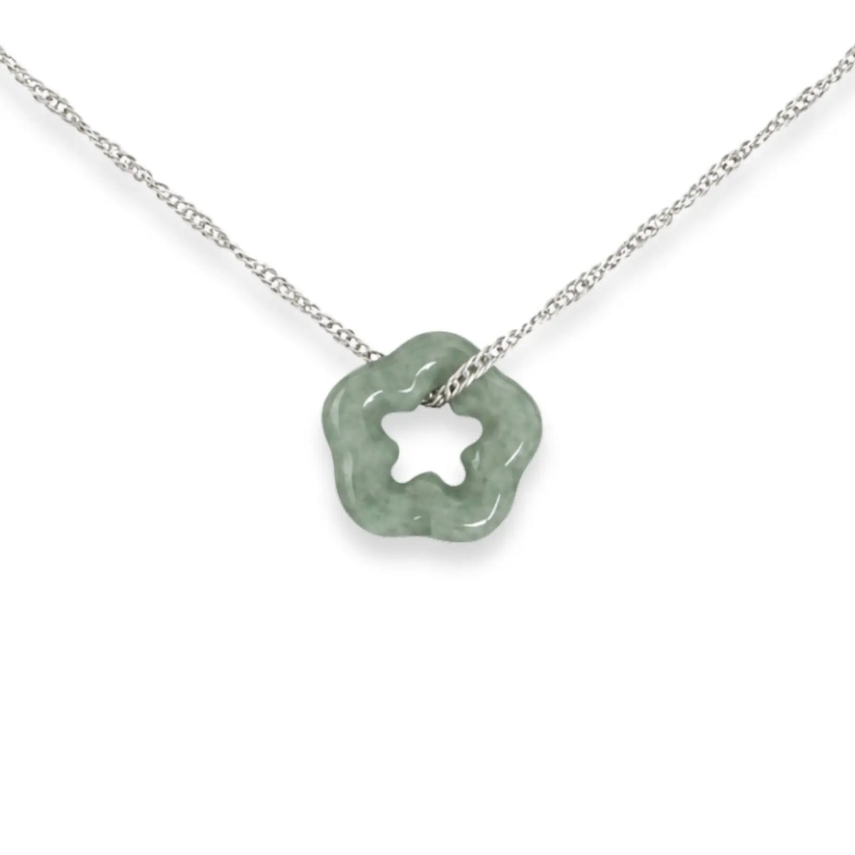 Necklace with a green flower pendant on a black card, placed on white fabric