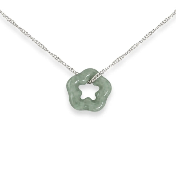 Necklace with a green flower pendant on a black card, placed on white fabric