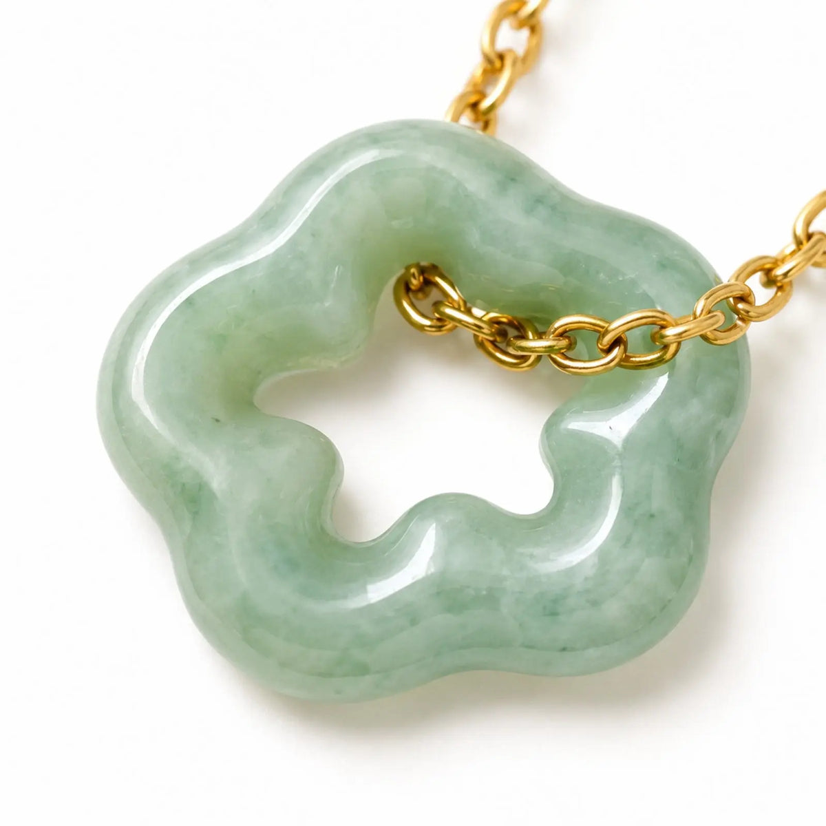 Necklace with a green pendant on a black display card against a white fabric background