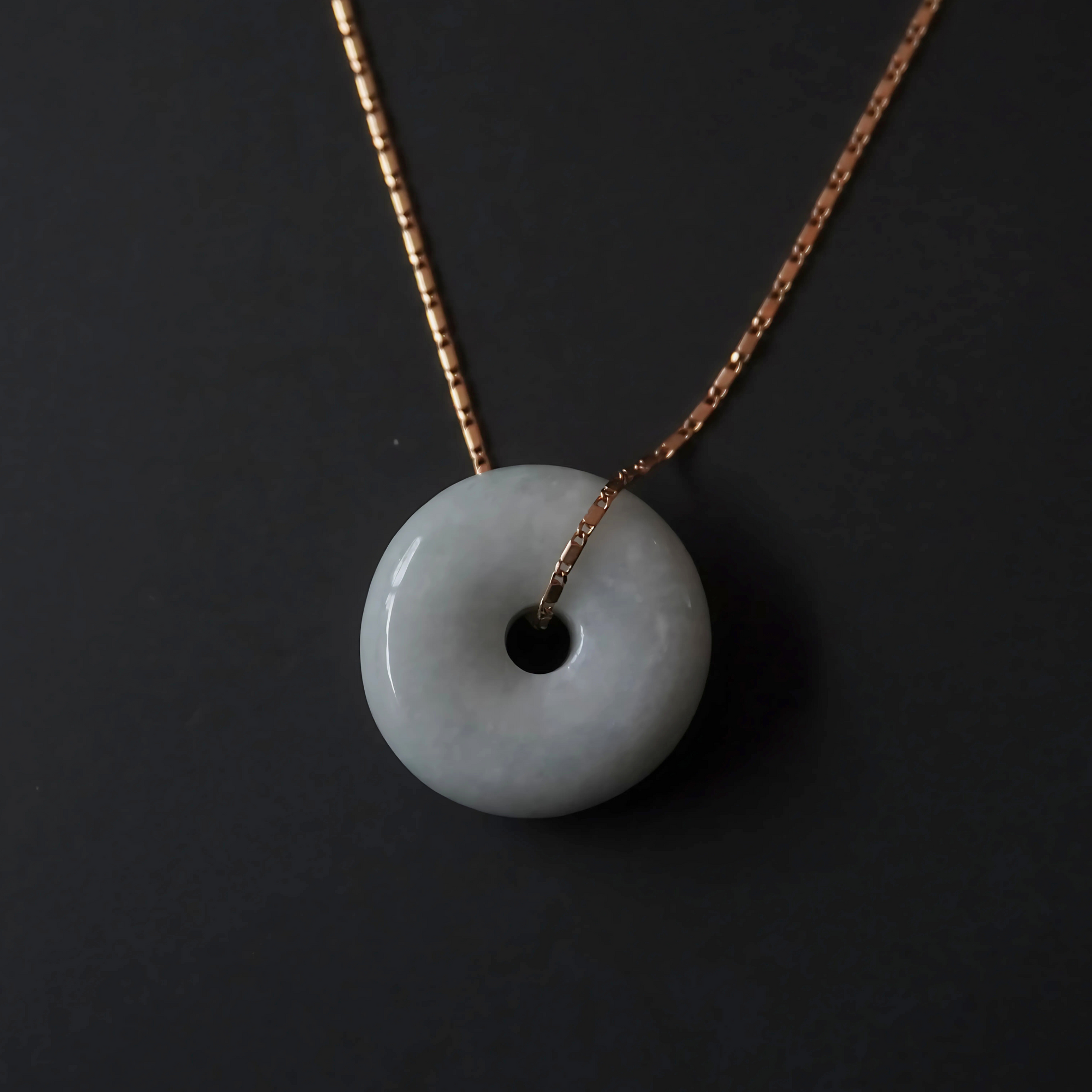 Minimalist jade donut pendant necklace with a 16-inch gold chain.