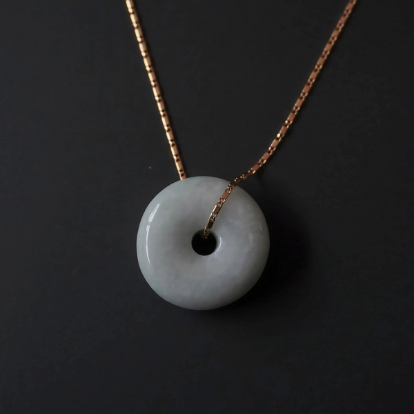 Minimalist jade donut pendant necklace with a 16-inch gold chain.